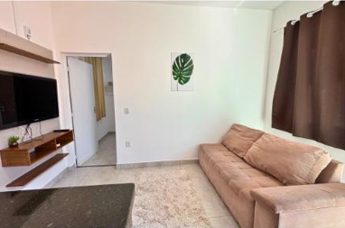 Sala integrada com sofá e televisão