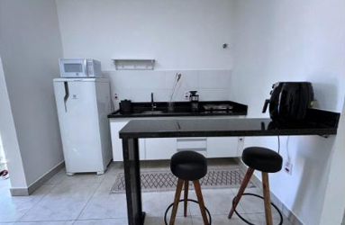 Cozinha equipada com geladeira, micro-ondas e bancada